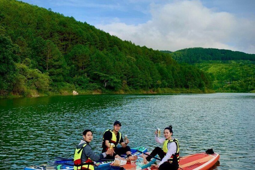 A group of people on a boat in a lake surrounded by forested hills. 1