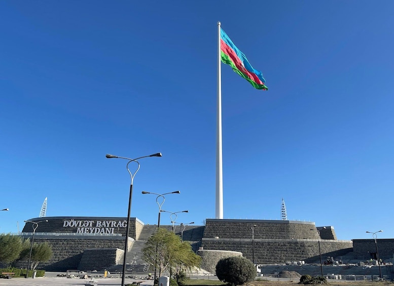 A flagpole with a flag, a building labeled 'DÖVLET BAYRAĞ MEYDANI', and a clear blue sky. 2