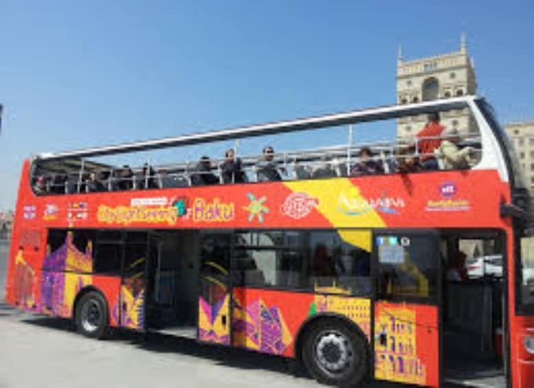 A double-decker bus with colorful advertisements and passengers. 4
