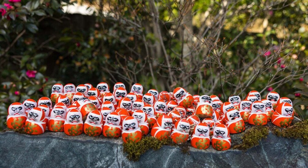 A collection of red and white painted eggs arranged on a stone surface. 3