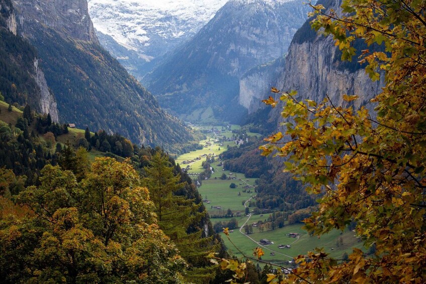A valley with steep cliffs, a river, and scattered buildings. 3