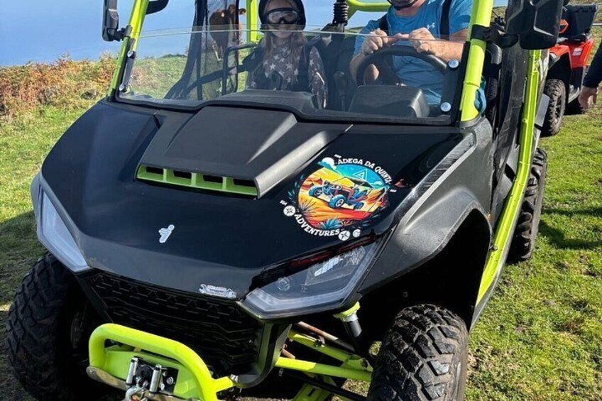 A green and black off-road vehicle with a sticker that reads 'Adventure 50'. 2