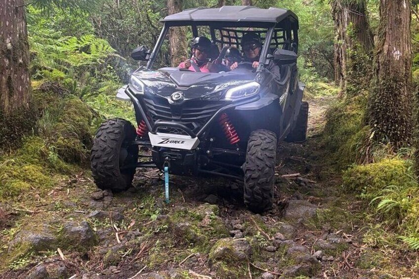 A black off-road vehicle with a ZORLACE logo on the front, navigating a forest trail. 3