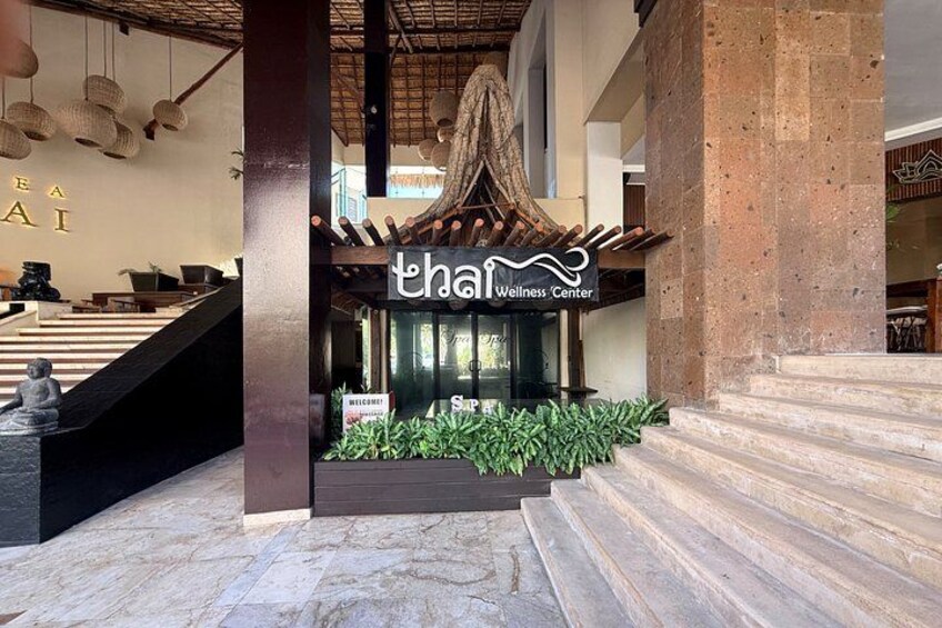 A wellness center with a traditional Thai architectural design, including a thatched roof and a sign with Thai script. 3