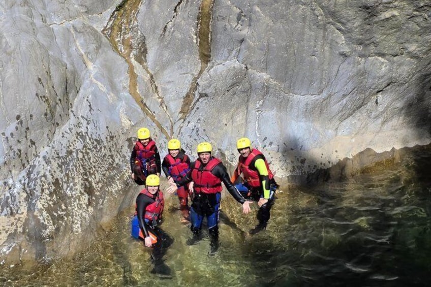 A group of people in a cave with water at the bottom. 2