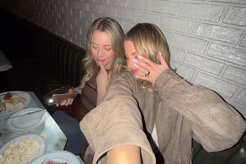 Twee personen zitten aan een tafel met eten en drinken. 2