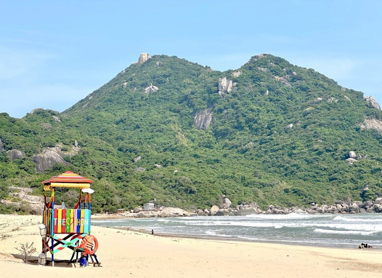 A beach with a colorful beach chair and a mountain in the background. 3