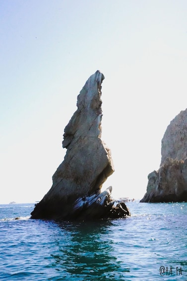 A rock formation in the sea with clear water around it. 3