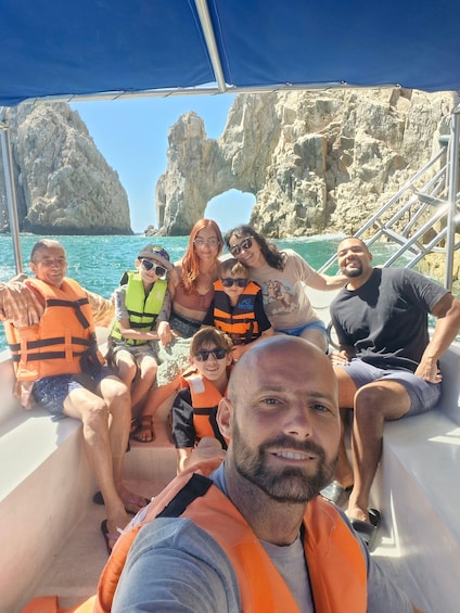 A group of people on a boat with rocky cliffs in the background. 5
