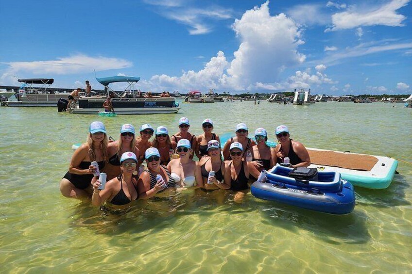 Un grupo de personas en un bote en un día soleado, rodeado de otras embarcaciones y agua. 3