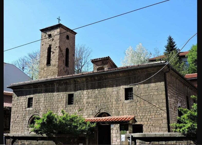 A stone church with a bell tower and arched windows. 4