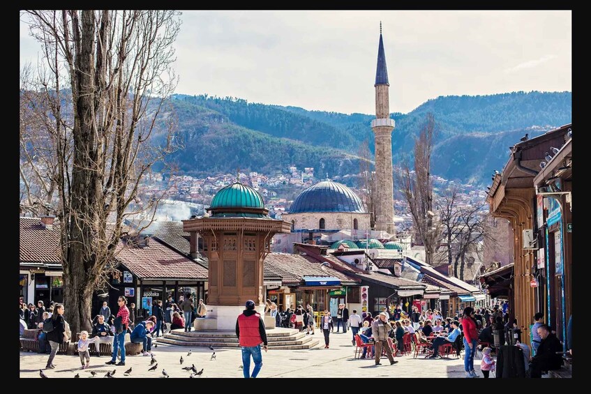 A bustling square with a prominent mosque, a minaret, and a dome. 3