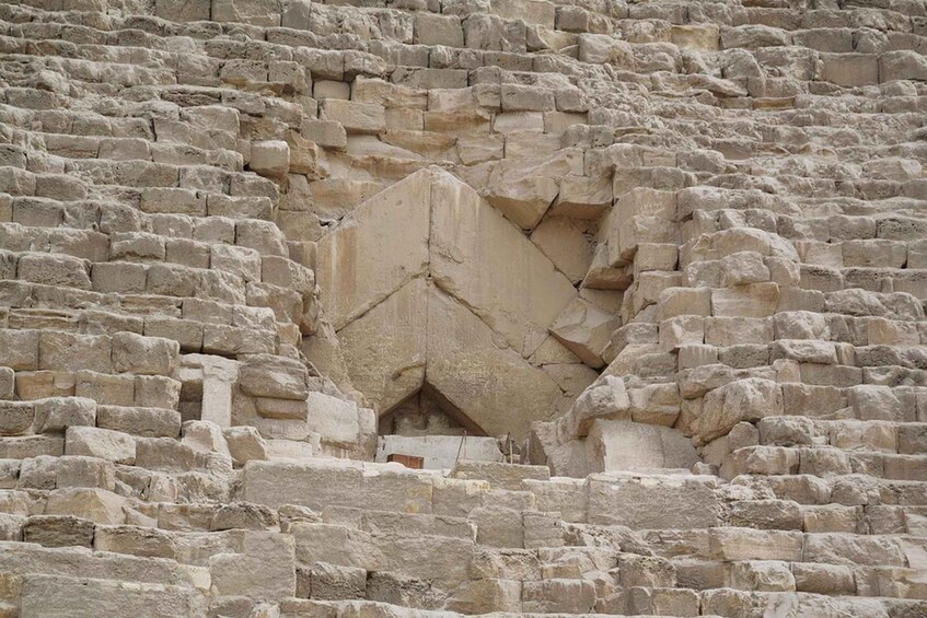 A stone wall with a large, irregularly shaped opening. 3