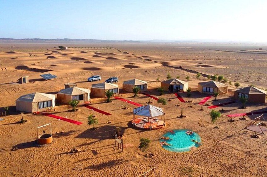 A desert resort with tents, a swimming pool, and a clear sky. 3