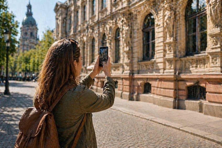 Una persona fotografiando un edificio histórico con arquitectura detallada. 3