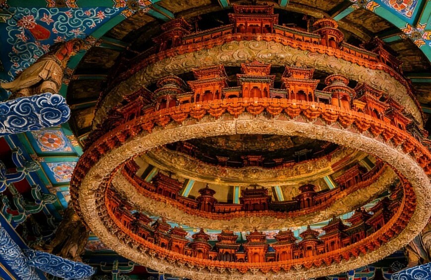 A multi-tiered, ornate architectural structure with intricate carvings and vibrant colors. 1