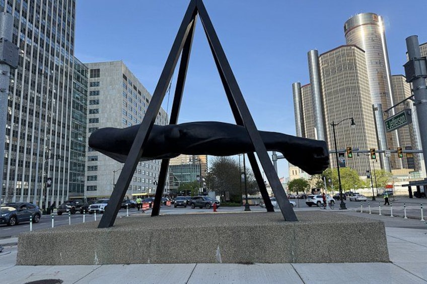 A modern sculpture in an urban setting with tall buildings in the background. 1