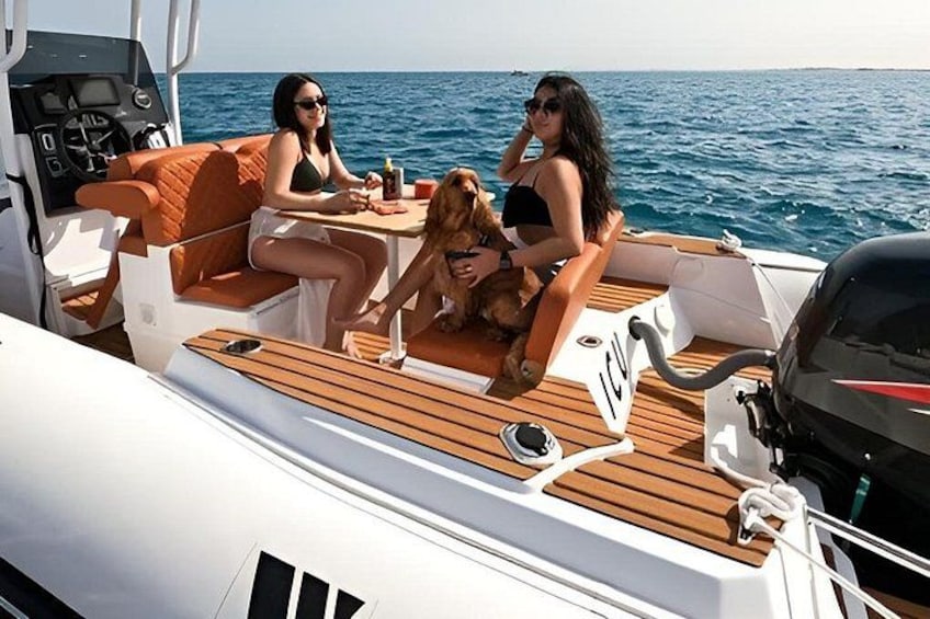 A boat with two people and a dog on deck, surrounded by water. 1