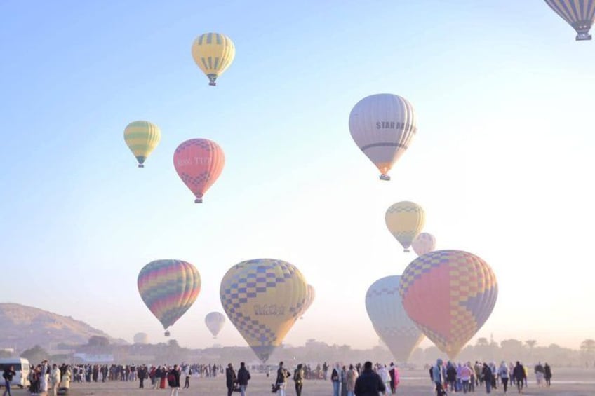 A hot air balloon festival with colorful balloons and a crowd of people. 2