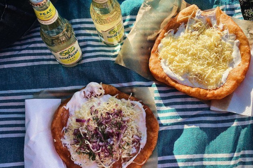 Deux pizzas sur une nappe à rayures, avec des bouteilles de bière. 5