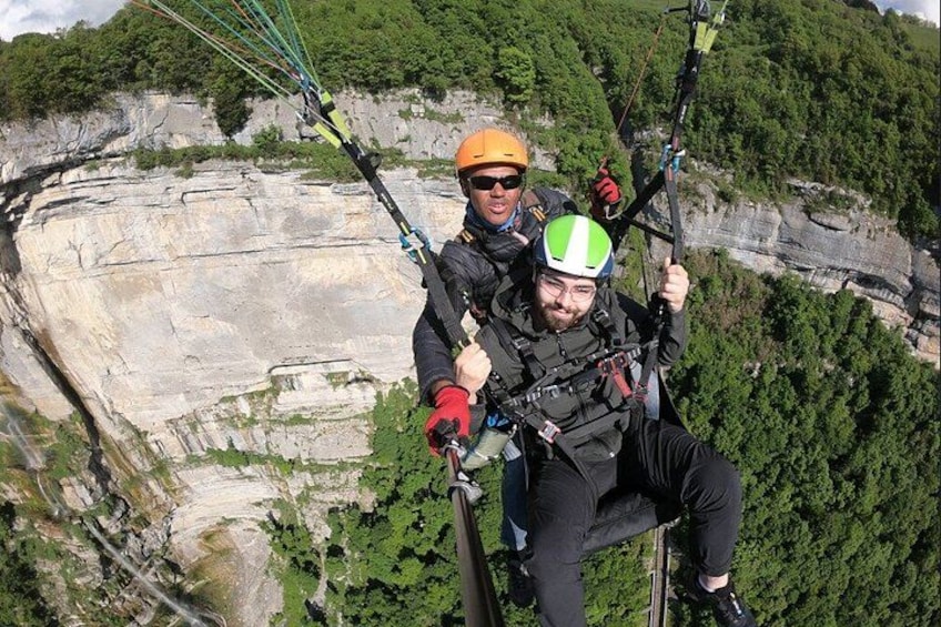 To personer paraglider med et bjergrigt landskab i baggrunden. 1