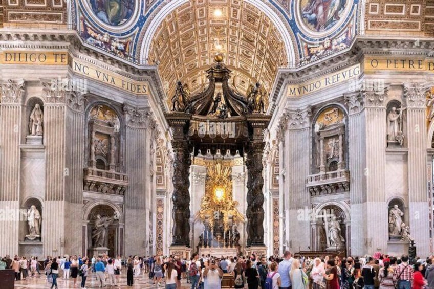 A grand interior with ornate decorations, a large central altar, and Latin inscriptions on the walls. 5
