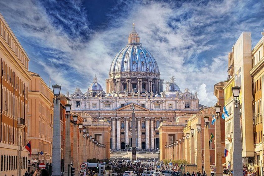 A grand building with a large dome, surrounded by historic architecture and a busy street. 1