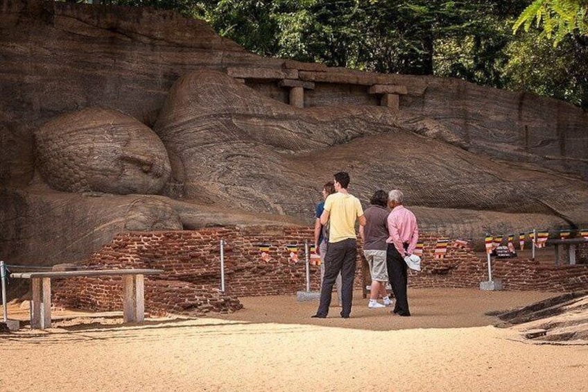 A large rock formation with people standing in front of it. 3