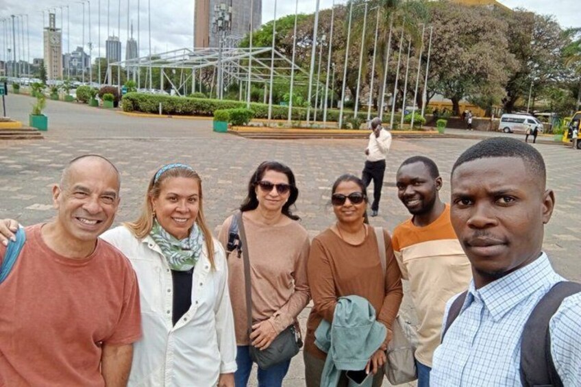 A group of people standing in a public square with a cityscape in the background. 5