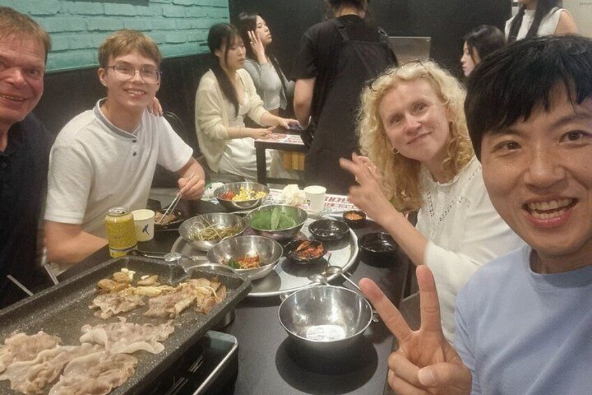 Un groupe de personnes est réuni autour d’une table dans un restaurant, où se trouvent différents plats. 4