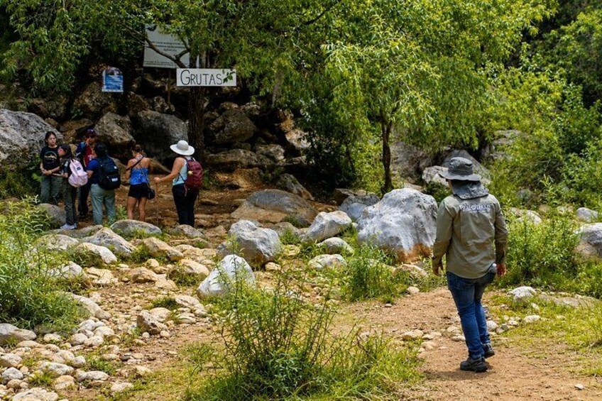 Un sendero para senderismo con grandes rocas y un cartel que dice 'GRUTAS'. 4