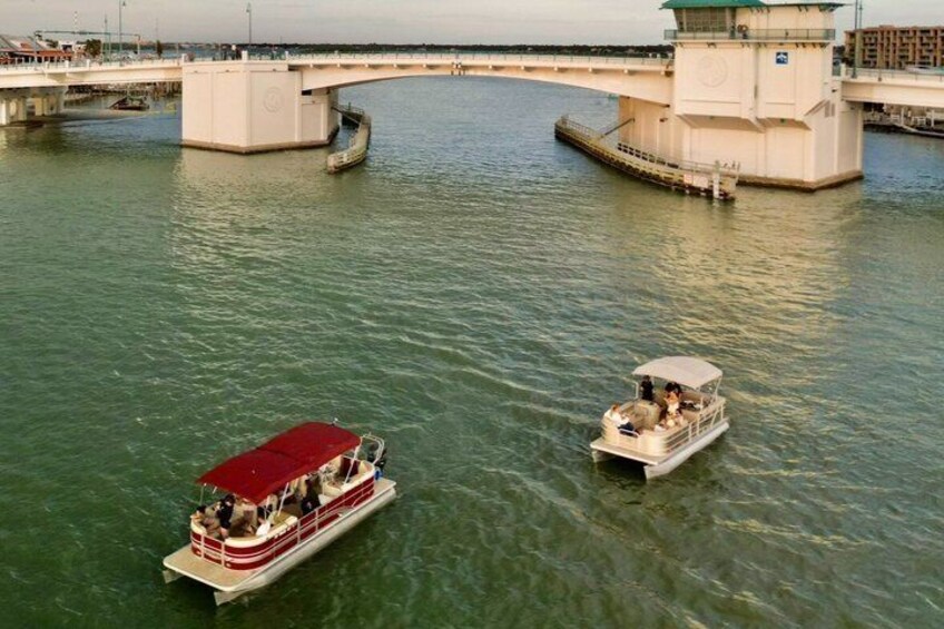 Un fiume con due imbarcazioni, una più grande dotata di una tenda rossa e un'altra più piccola, entrambe ormeggiate vicino a un ponte. 5