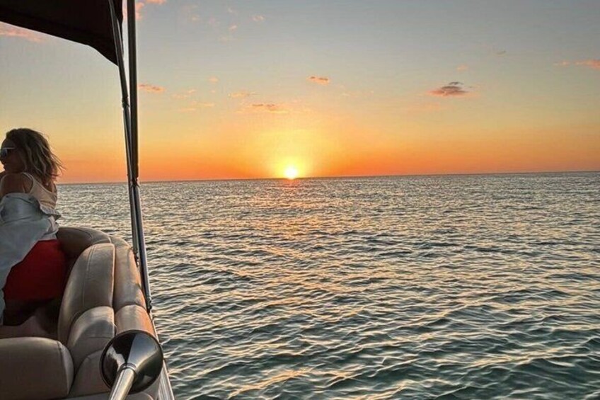 Tramonto sull'oceano con una barca e una persona sul ponte. 3