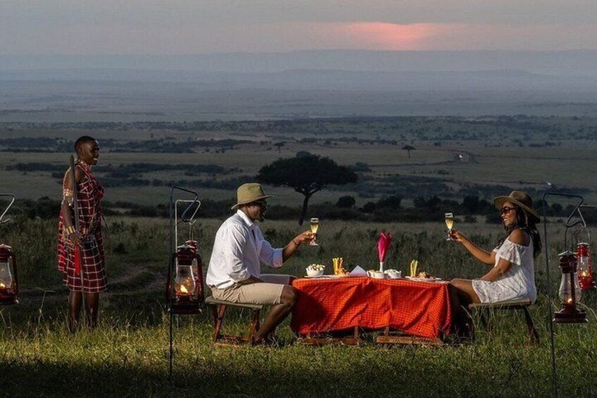Un groupe de personnes est réuni autour d’une table à l’extérieur, profitant d’une vue sur un paysage. 2