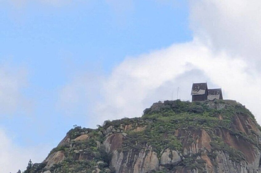 A mountain with a building on top. 1