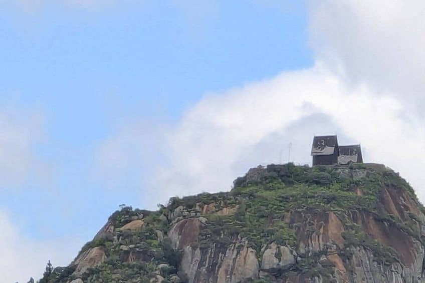 A mountain with a building on top. 1