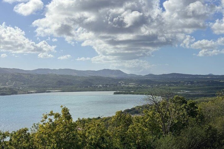 Un lago rodeado de colinas y árboles bajo un cielo parcialmente nublado. 4