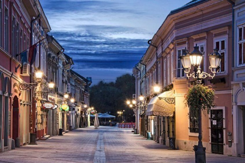 Une rue bordée d’immeubles, d’éclairages publics et sous un ciel dégagé. 5