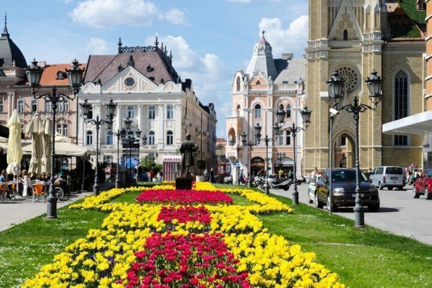 Une rue bordée de fleurs, avec des bâtiments historiques et une église. 2