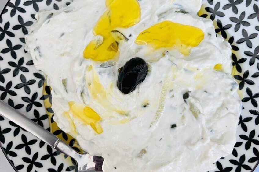 A bowl of creamy dip with yellow and black toppings. 1