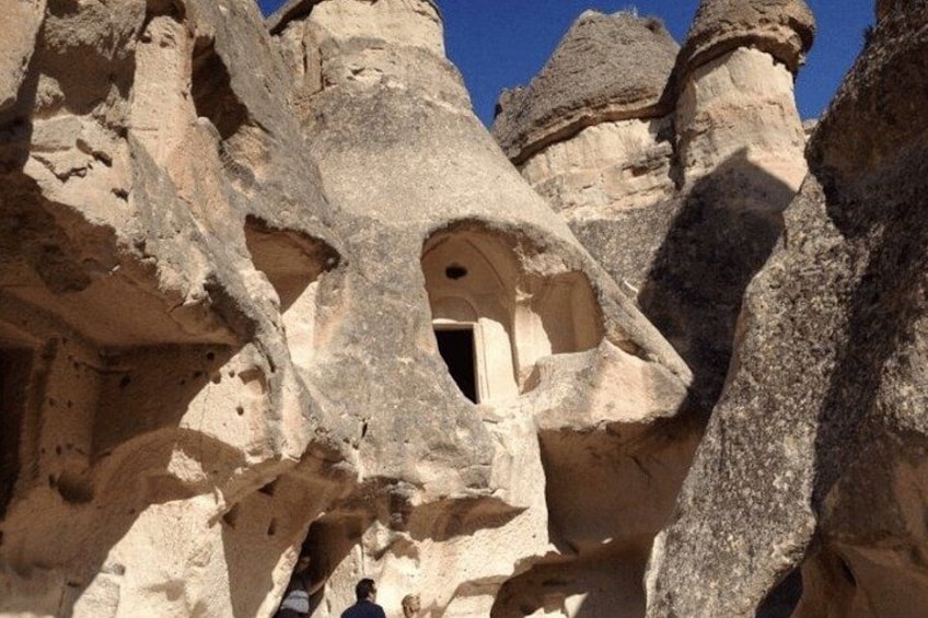 A cave entrance with a small opening and a person standing inside. 5