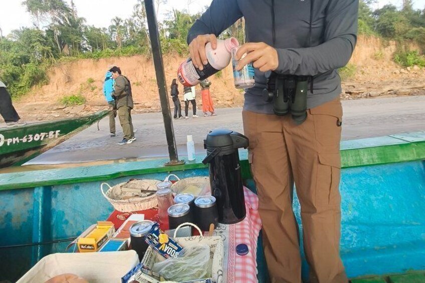 Una persona manipula un recipiente rosa en un barco, con varios objetos como una hielera, botellas y una bolsa en la cubierta. 5