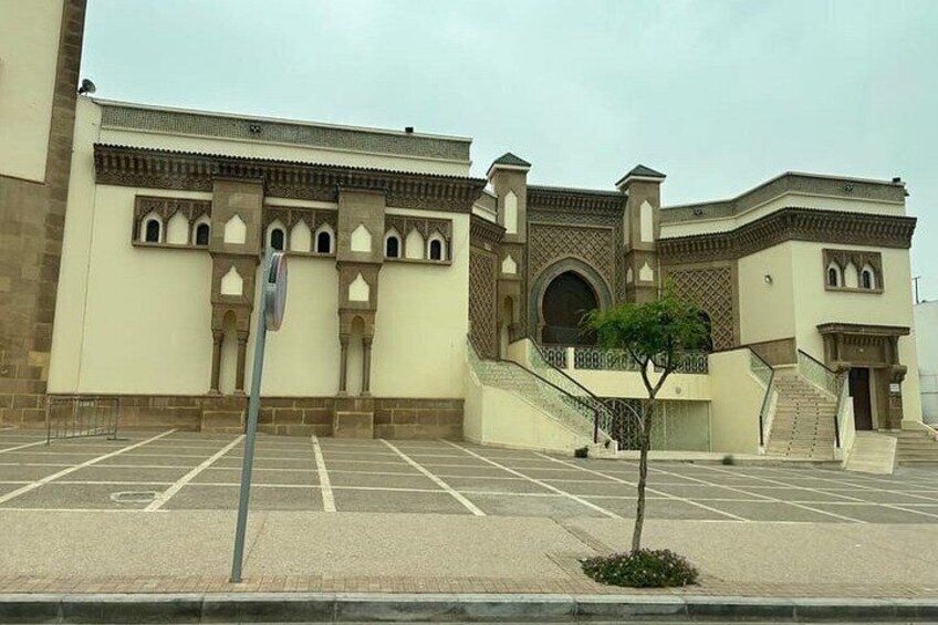 Un parcheggio con un edificio caratterizzato da finestre ad arco e una scala. 5