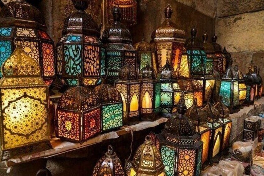 Una composizione di lanterne finemente decorate con motivi geometrici e calligrafia, esposta in un ambiente poco illuminato. 4