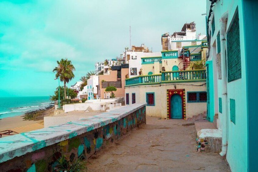 Una cittadina costiera con edifici colorati, una spiaggia e una palma. 1