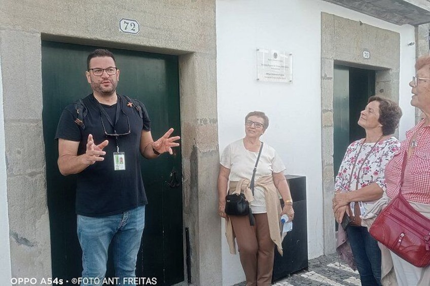 Un uomo che gesticola vicino a una porta, con due donne e un bambino nelle vicinanze. 5