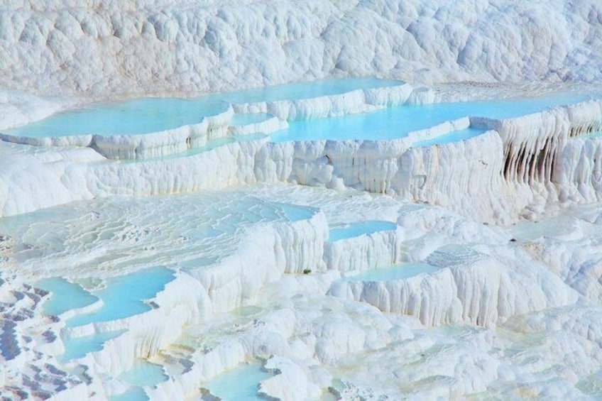 Des formations de travertin en terrasses, avec des bassins d’eau. 1