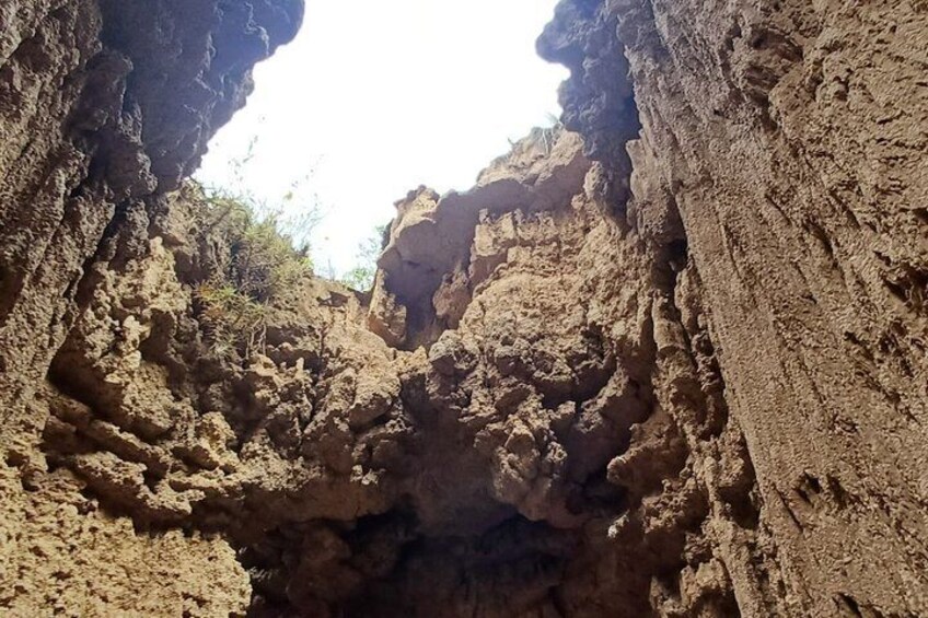 A rocky canyon with steep walls and a narrow passageway. 3