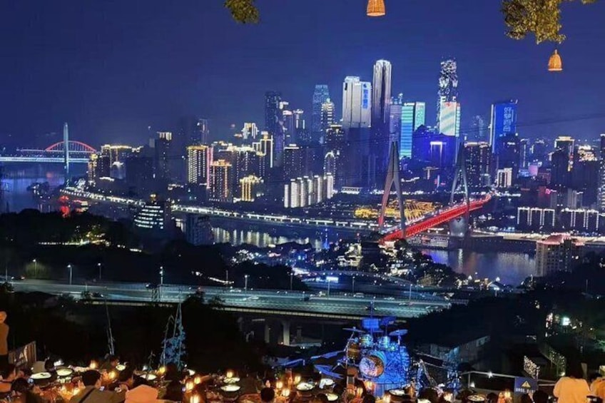 A city skyline at night with illuminated buildings, a prominent red bridge, and a river. 3