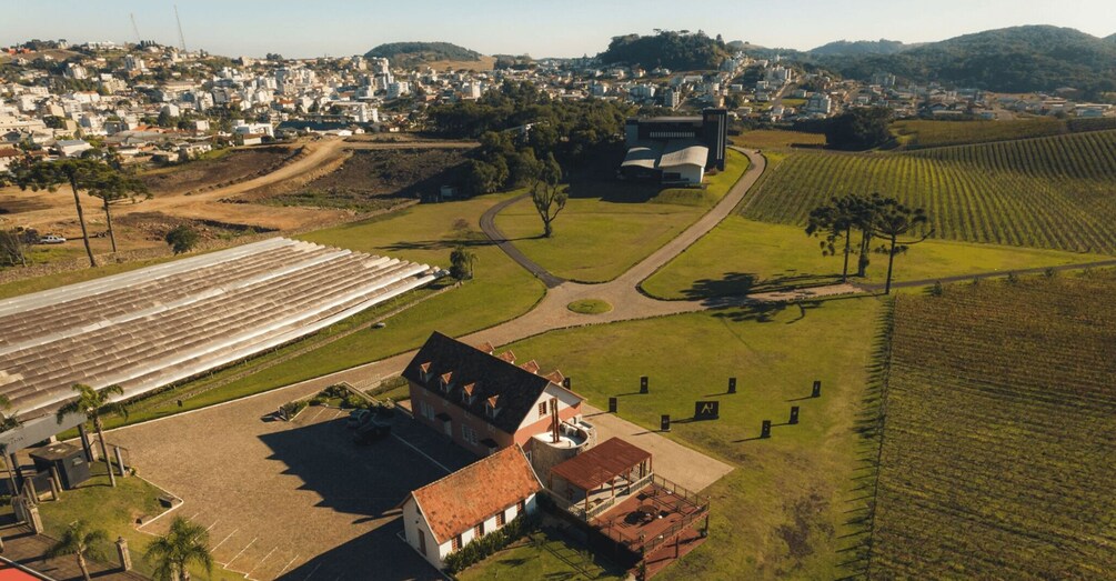 A vineyard, a large greenhouse, and a historic building with a red roof. 3